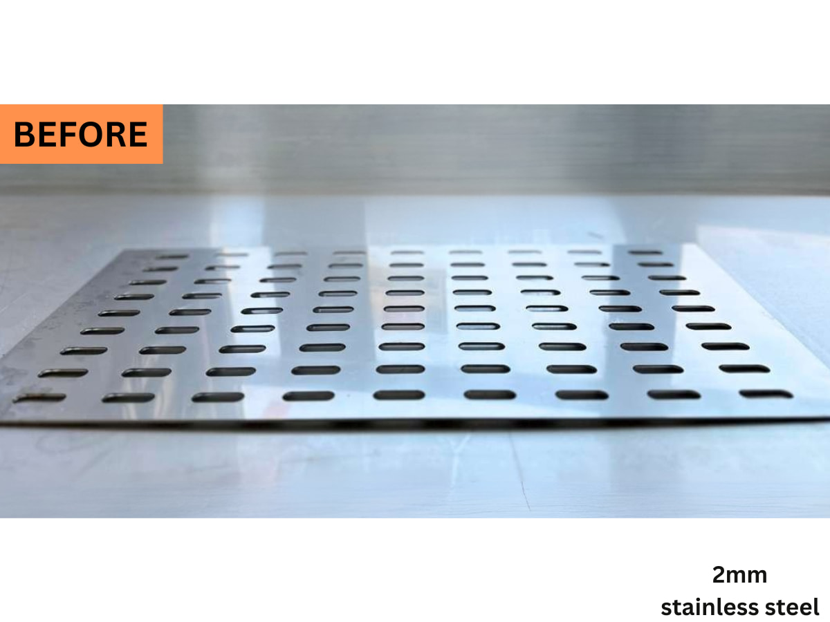 Düzleştirme öncesi kenarları yüzeyden kalkmış 2 mm oval delikli paslanmaz çelik panel